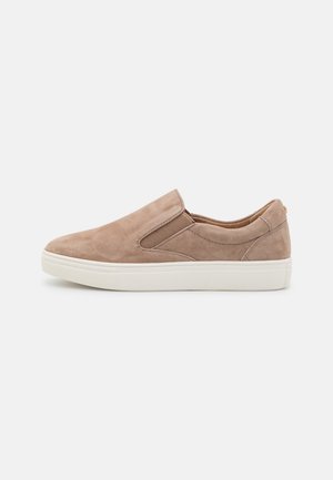 Lys brun ruskind slip-on sneaker med elastiske sidepaneler og hvid gummisål, vist i sideprofil på hvid baggrund.