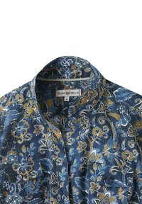 Chemise à boutons fleuris avec un motif bleu et or, dotée d'un col et d'une poche plaquée sur le côté gauche. Fabriquée en tissu léger.