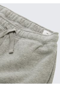 Grijze joggingbroek van zacht, gestructureerd materiaal met een tailleband met trekkoord. Voorzien van elastische boorden en een klein binnenlabel.