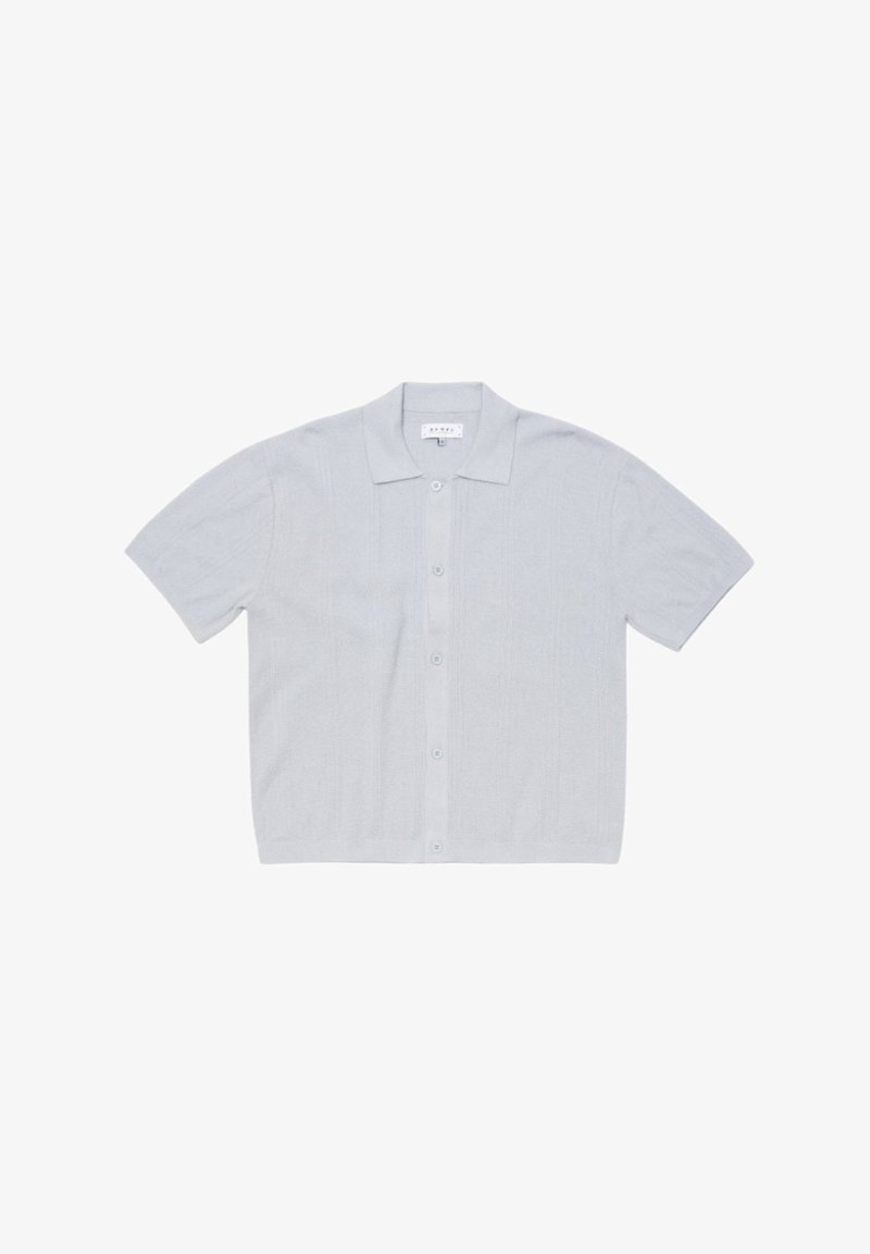 Polo en maille gris clair à manches courtes avec boutonnage sur le devant et petit col, étalé à plat sur fond blanc.