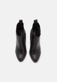 Black ankle boots with a smooth leather exterior, pointed toe, and elastic side panels. Rubber soles provide traction; pull tabs at the rear.