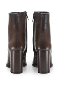 Stivaletti in pelle marrone con tacco alto a blocco, texture liscia e cerniere metalliche sul retro per una facile calzata.