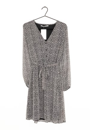 Vestido floral en blanco y negro con mangas largas, escote en V y cinturón de lazo. Tejido ligero y transparente con un corte holgado y un dobladillo acampanado.