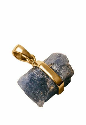 Engaste de colgante de oro que sostiene una piedra preciosa azul oscuro y en bruto con texturas naturales y forma irregular sobre un fondo blanco.