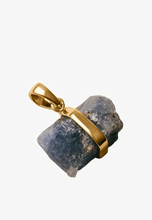 Engaste de colgante de oro que sostiene una piedra preciosa azul oscuro y en bruto con texturas naturales y forma irregular sobre un fondo blanco.