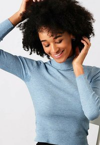 Lyseblå, ribbet turtleneck-sweater med et tætsiddende design. Lange ærmer og rullet hals. Glat tekstur og tætsiddende silhuet.