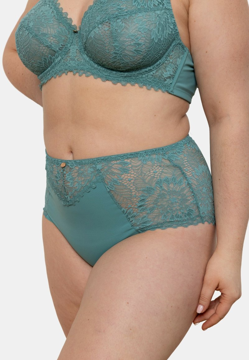 Ensemble de bralette en dentelle teal et culotte haute avec des panneaux de dentelle florale, des bords festonnés et un accent de quincaillerie décoratif sur la culotte.
