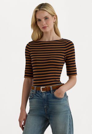 Haut rayé avec des lignes horizontales bleu marine et orange, décolleté bateau et manches courtes, associé à un jean bleu délavé taille haute et une ceinture marron.