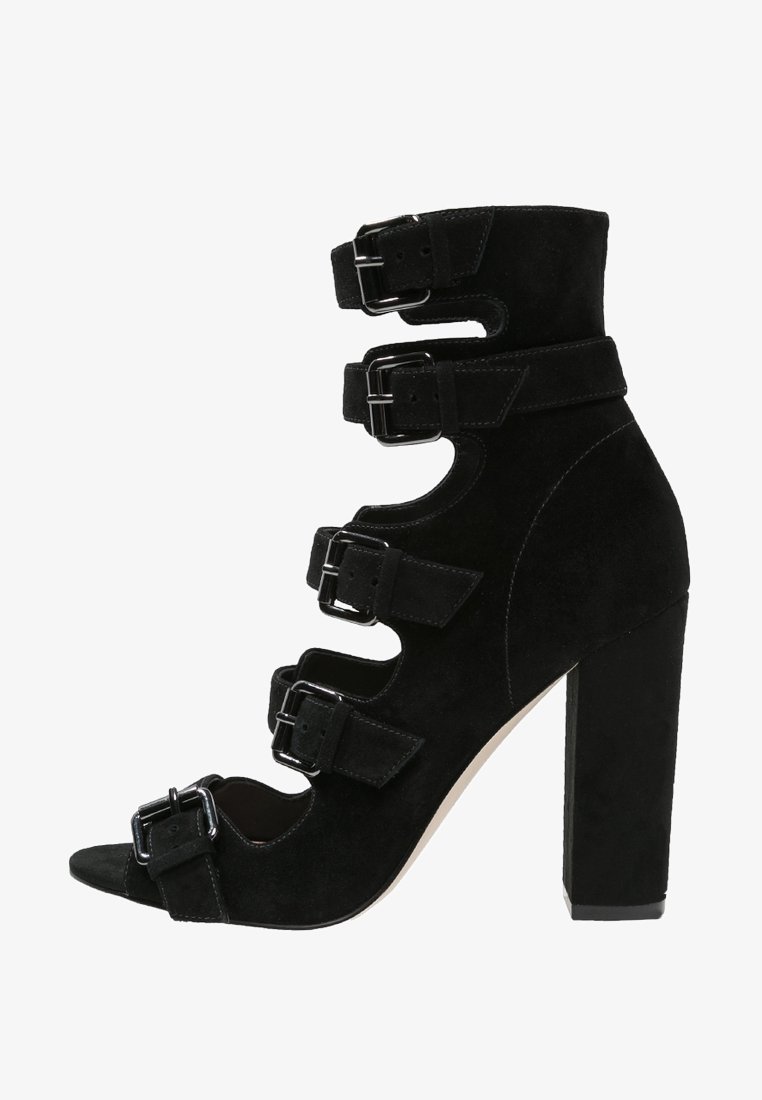 Sandale à talon haut en daim noir avec cinq brides à boucles ajustables et un talon bloc épais.