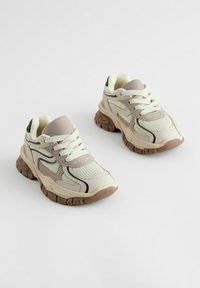 Sneakers med øvre i mesh i creme og lys grå, sorte detaljer, polstret krave, hvide snørebånd og en tyk, struktureret gummisål.
