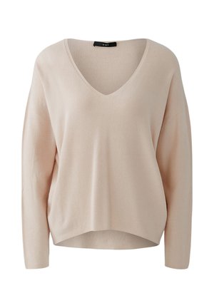 Pull long à manches longues beige clair avec un col en V, fabriqué à partir d'un tissu en tricot côtelé. Coupe décontractée et épaules tombantes.