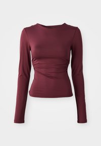 Bordo dugi rukav majica napravljena od rastezljivog materijala. Ima prilagođeni kroj s nabransom na struku i dekolteom u obliku žlice.
