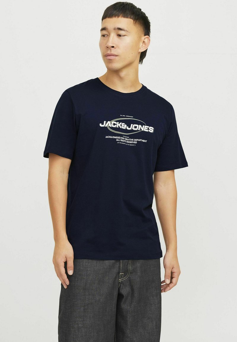 Marineblå bomulds T-shirt med kortærmer, der har hvid trykt tekstbranding på brystet. Casual pasform med rund halsudskæring.