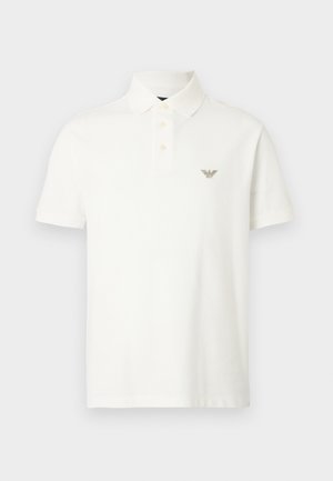 Polo bianca in cotone, con collo classico, patta a tre bottoni e un logo ricamato discreto sul petto.