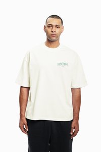 Krēmkrāsas kokvilnas T-krekls ar vaļīgu pieguļumu, ar zaļu "Favela Limited" logotipu kreisajā krūtīs un īsām piedurknēm. Bez ievērojamām rakstu zīmēm.