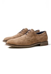 Chaussures en daim marron à lacets avec une texture lisse, bout arrondi et semelle en caoutchouc contrastante. Présente des lacets navy et des accents rouges subtils.