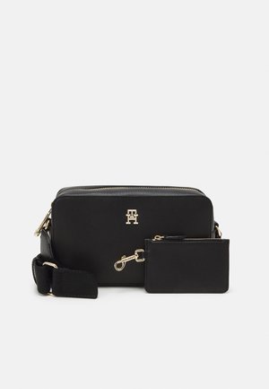 Czarna prostokątna torebka na ramię z regulowanym paskiem oraz dopasowaną małą saszetką z metalowymi elementami w kolorze złota i logo na przodzie.
