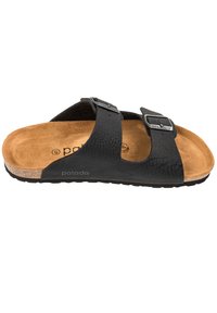 Zwarte leren slipper met twee verstelbare metalen gespen, kurk tussenzool en een bruin suède voetbed met een gestructureerde afwerking.