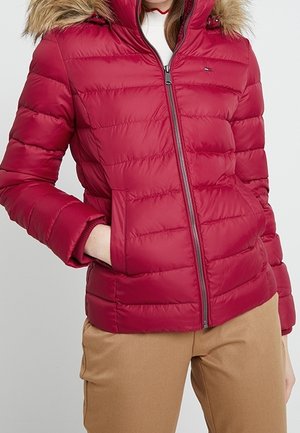 Red puffer jacket with a zip front, horizontal stitching, and a detachable fur-lined hood. Features side pockets and elastic cuffs.