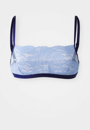 Lys blå blonde bralette med blomstermønster, der har marineblå stropper og underbånd for kontrast. Glat tekstur, trådløs design.