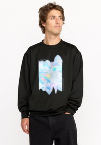 Sweatshirt noir avec un graphique abstrait coloré dans des nuances de bleu, rose et argent, avec un col rond et des poignets côtelés.