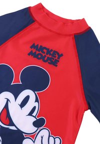 Rash guard rojo y azul marino con un gran gráfico de Mickey Mouse, hecho de material elástico con cuello alto y costuras contrastantes.
