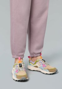 Bunte Sneakers mit einer Mischung aus Texturen, darunter Wildleder und Mesh, mit rosa, grünem und blauen Akzenten sowie gemusterten Schnürsenkeln.