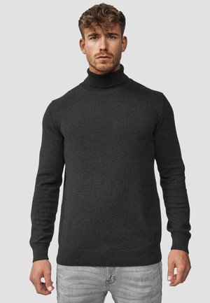 Mørkegrå turtleneck sweater med lange ærmer, ribbede manchetter og kant. Strikket tekstur, tætsiddende silhuet. Brugt med lysegrå jeans.