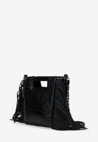Bolso de mano negro con textura de cocodrilo, que cuenta con detalles de flecos laterales y un asa con corte rectangular. Incluye correa de cadena.