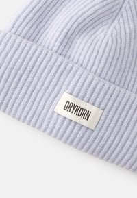 Gorro de malha canelada lilás com um rótulo branco exibindo o nome da marca "DRYKORN". Textura suave com riscas verticais.