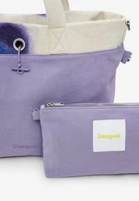 Borsa a spalla in tela viola con parte superiore beige a contrasto, dotata di chiusura con coulisse, di una piccola pochette con zip abbinata e di un dettaglio logo.