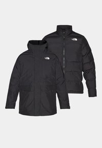 Sort The North Face vendbar jakke med lynlås foran, høj krave og to frontlommer, vist fra front- og bagvisning.