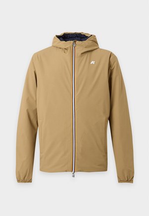 Veste à capuche beige avec fermeture éclair intégrale à l'avant, poignets élastiques, poches latérales et petit logo sur la poitrine sur fond blanc.