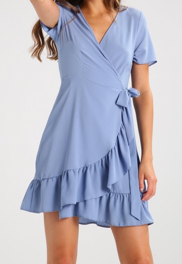 Robe portefeuille bleu clair en tissu doux, avec manches courtes, détail noué à la taille et ourlet à volants.