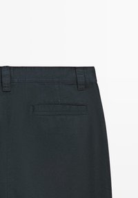 Black trousers with a smooth, textured finish, featuring a belt loop waistband and a single, rectangular back pocket with no visible hardware.