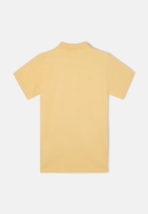 Polo de manga corta en suave y liso tejido amarillo. Presenta un cuello clásico y un ajuste entallado sin marcas ni patrones visibles.