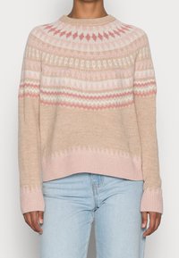 Ljust beige stickad tröja med rundad halsringning. Har ett mönstrat mönster i mjuk rosa och vit, ribbade muddar och en något kortad passform.