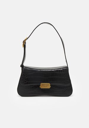 Bolso de cuero negro con relieve de cocodrilo, placa de logotipo rectangular en tono dorado y correa ajustable con hebilla.