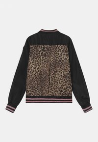 Mustat takki leopardikuosisella takapaneelilla sekä vaaleanpunaraidallisilla ribbineuleilla hihoissa, helmassa ja kauluksessa, näkyy takaa valkoista taustaa vasten.