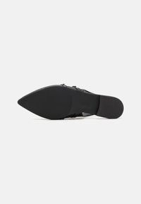 Schwarzer hochhackiger Schuh mit spitzer Zehe, glattem Ledertextur und schmalem Absatz. Die Laufsohle ist flach mit einer strukturierten Oberfläche für besseren Halt.