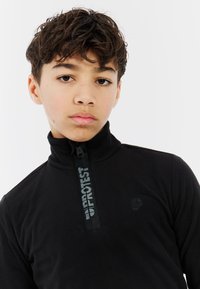 Czarny polarowy półgolf z wysokim kołnierzem, z zamkiem błyskawicznym na ćwierć długości oraz detalem logo z przodu w czerni. Miękka tekstura i dopasowany krój.