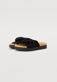 Sandale negre din suede, cu o talpă căptușită, având o curea cu mărgele negre și o talpă din cauciuc texturată. Design cu vârful deschis pentru o purtare ușoară.
