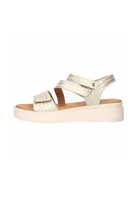 Light gold flat sandals with a textured crocodile pattern, featuring two adjustable straps and a thick white platform sole.