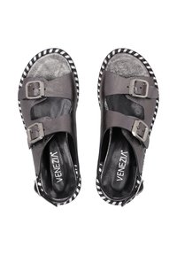 Schwarze Ledersandalen mit zwei silbernen Schnallen, einer strukturierten Fußbett und einer schwarz-weißen gestreiften Sohle.