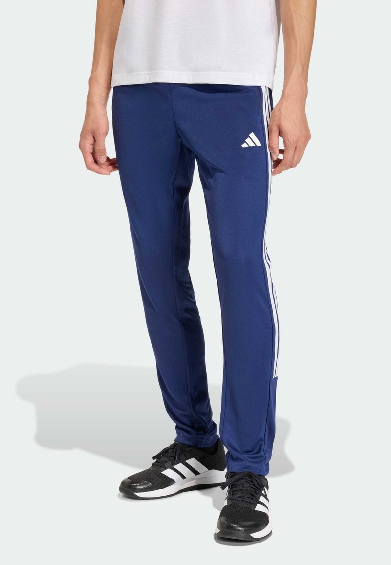 Μπλε σκούρο αθλητικό παντελόνι με λευκές πλαϊνές ρίγες, εφαρμοστή γραμμή, κατασκευασμένο από απαλό, ελαφρύ ύφασμα, με ελαστική ζώνη μέσης για άνεση.