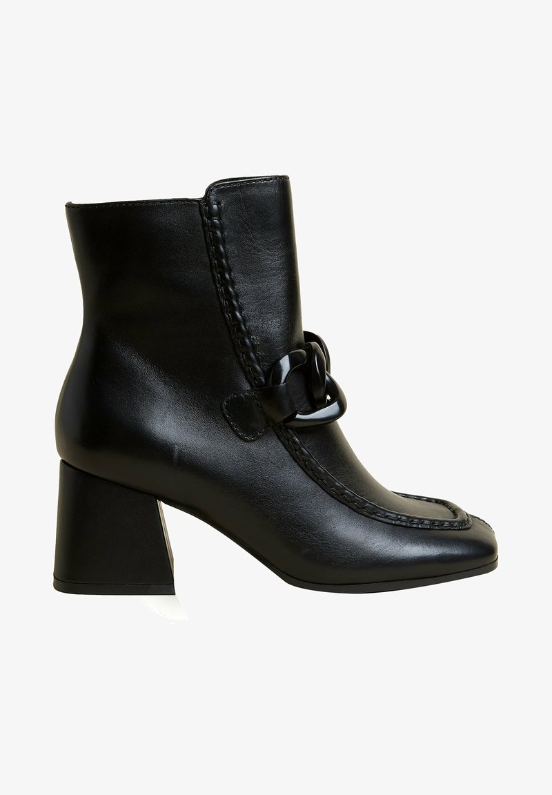 Bottine en cuir noir avec bout carré, talon moyen épais, détail décoratif chaîne noire et couture avant surpiquée.