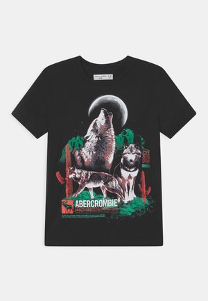 Schwarzes Kinder-T-Shirt mit Grafik von drei Wölfen, einer heult den Mond an, Kakteen und „Abercrombie“-Schrift in Grün, Rot und Weiß.