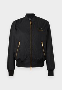 Μαύρο bomber μπουφάν με λεία υφή, λεπτομέρειες με χρυσό φερμουάρ και λογότυπο στο στήθος. Διαθέτει ριμπ μανσέτες και ζώνη στη μέση.
