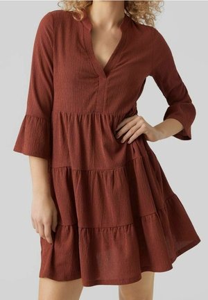 Robe couleur rouille, à niveaux, avec des manches trois-quarts, un décolleté en V et un tissu texturé, présentant des accents de volants aux manches et à l'ourlet.