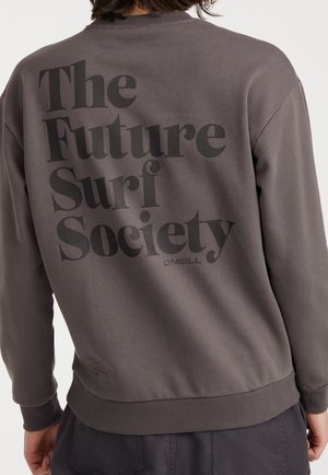 Grå sweatshirt med stor svart text "The Future Surf Society" på baksidan. Ribbad mudd och nederkant, mjuk textur. Varumärkeslogotyp på nedre höger sida.